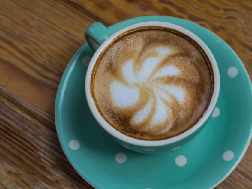Cappuccino mit Latte-Art in einer türkisen Tasse