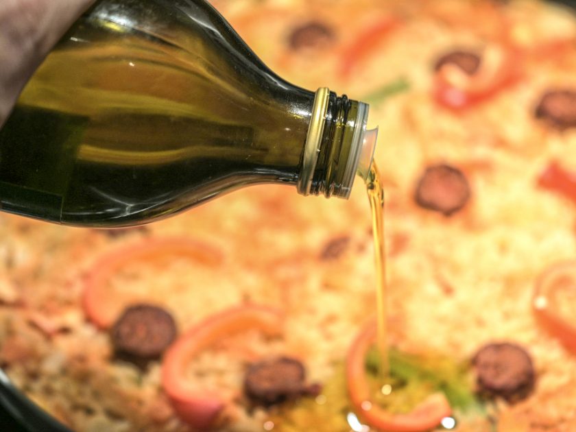 Olivenöl wird über eine frisch gebackene Pinsa gegossen