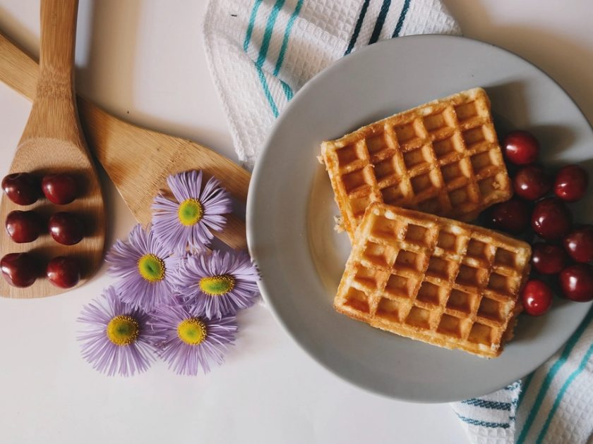 Zwei Waffeln mit frischen Kirschen auf einem Teller